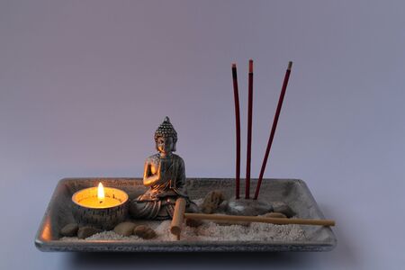 small zen garden with buddha candle and incenseの写真素材