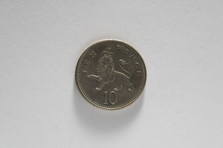 British currency. Ten 10 10p Pence coin featuring a crowned Lion. Isolated on a white background. Money.の写真素材
