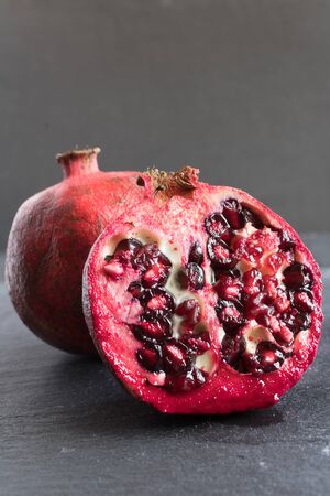 ripe red pomegranate and grain on a gray stone backgroundの写真素材