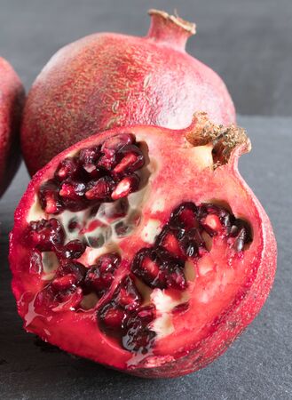 ripe red pomegranate and grain on a gray stone backgroundの写真素材