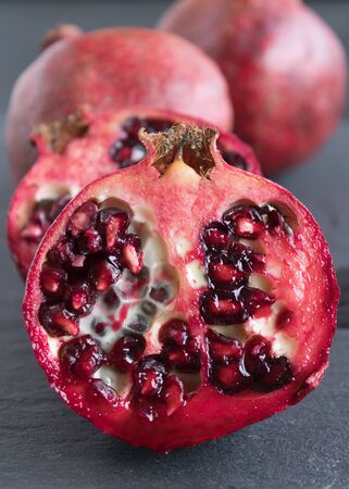 ripe red pomegranate and grain on a gray stone backgroundの写真素材