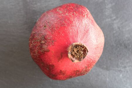 Group of one whole four pieces of fresh red pomegranate on grey stoneの写真素材