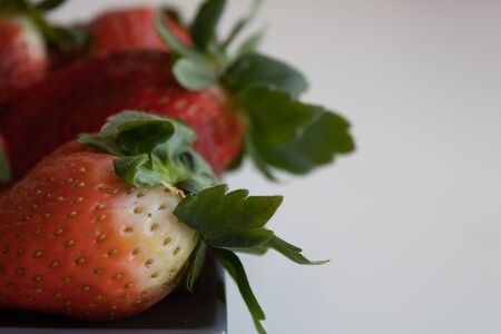 Strawberries on gray ceramic plate with white background. advertising photographyの写真素材