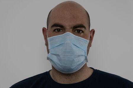 Bald man with mask on whiteの写真素材