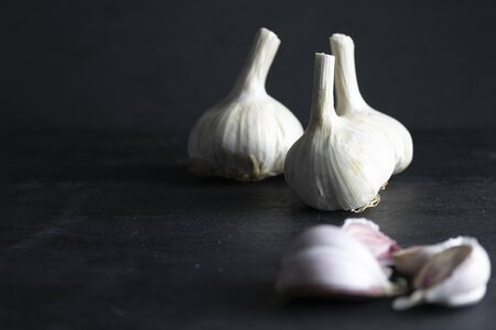 garlic cloves and unfocused garlic heads on a black background. dark foodの写真素材