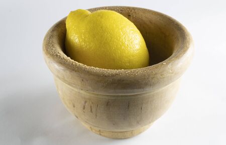 Lemon and wooden bowl insulated fresh on a white backgroundの写真素材