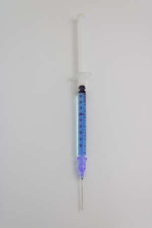 needle syringe with isolated blue medicine on white backgroundの写真素材