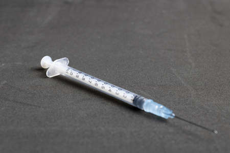 syringe with isolated needle on a clean gray backgroundの写真素材