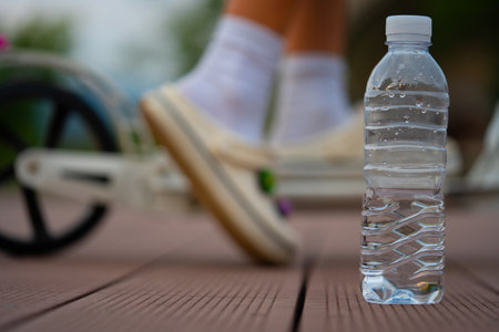 A bottle of clean water and a scooter wheel. After exercise on a summer evening.の写真素材