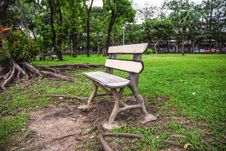Empty Wooden Bench at the Park in the Cloudy Dayの写真素材