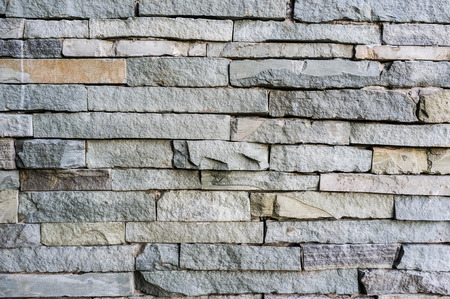 modern stone wall made of rough rock and cementの写真素材