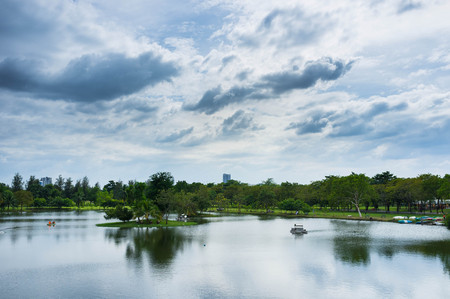 landscape of bangkok public park with cloudy sky and fresh lakeの写真素材