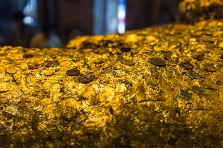 old buddha sculpture covering with gold paperの写真素材