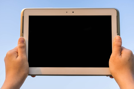 hand holding tablet in the sky looking at screen