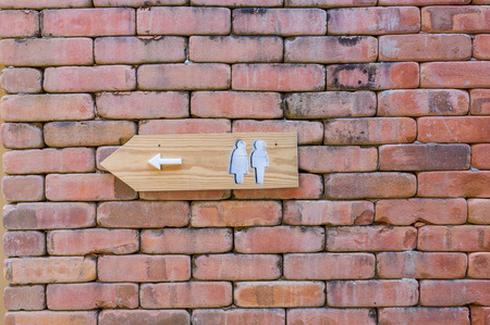 restroom direction sign in brick wallの写真素材