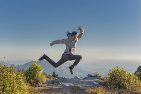 happiness, freedom, vacation .Man jumping on the top mountain