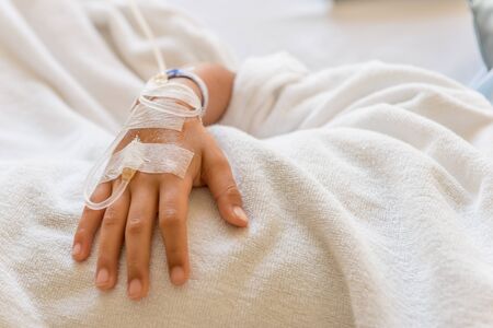 Saline intravenous drip on children hand in hospital. Health care and Medical equipment concept.