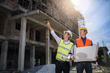 Businessman engineer looking blueprint in a building to  discussion with architects at construction...