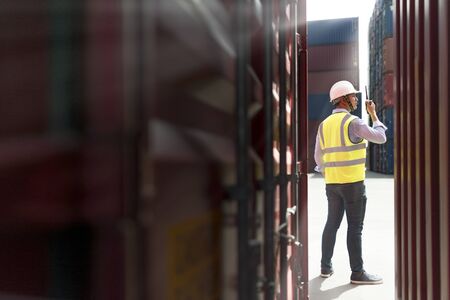 Foreman control loading Containers box from Cargo freight ship