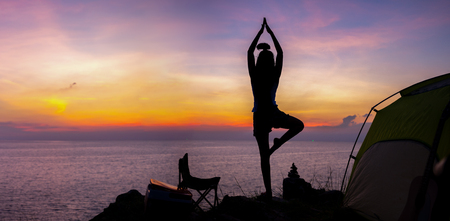 Young woman practicing yoga in the nature.female happiness. Landscape backgroundの写真素材