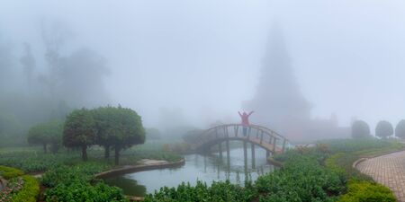 Traveller alone open arms and looking at foggy garden , travel , adventure , lifestyleの写真素材