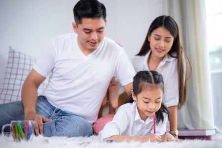 Young family drawing together with colorful pencils at home, kids and happy people concept.の写真素材