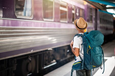 Traveler waits train at train station for travel in summer. Travel concept.の写真素材