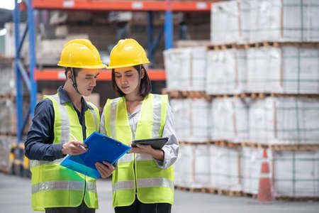 Warehouse worker checking packages on shelf in a large storeの写真素材