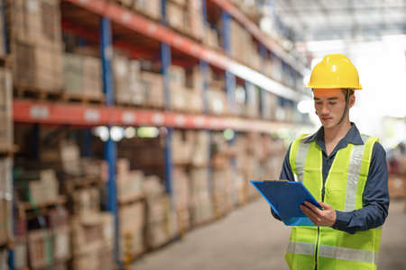 Warehouse worker checking packages on shelf in a large store