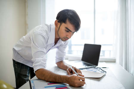 Business man working with laptop and documents on his desk.analyzing data in officeの写真素材