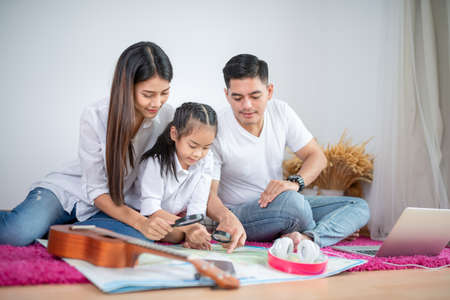 happy family mother, father, child daughter play laptop computer at homeの写真素材