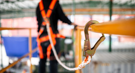 Construction worker wearing safety harness and safety line working at high place