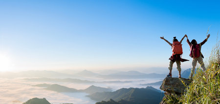 Group of happy hiker raised up arms on the mountain. successful climbers