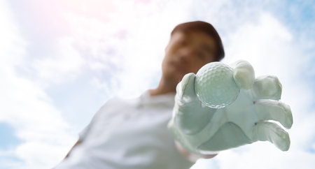 Golfer putting golf ball on tee on golf course. Hand putting golf ballの写真素材