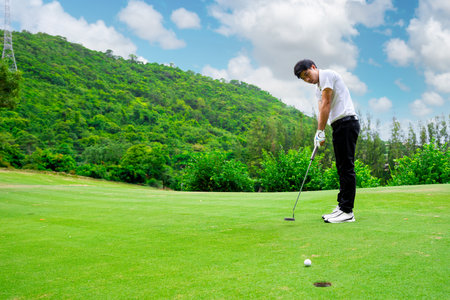 Golfer is using a putter to put a golf ball on the green. sport golf clubの写真素材