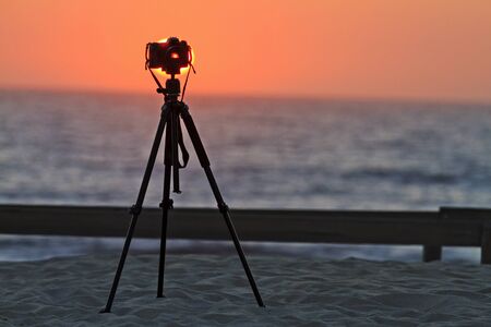 camera on a tripod at the beach, sunset, SLR cameraの写真素材