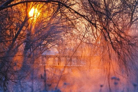 beautiful winter sunrise over a foggy river and bridge