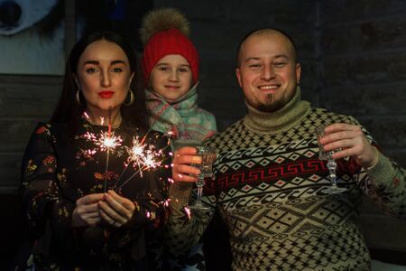 family celebrating with wine glasses and sparklers