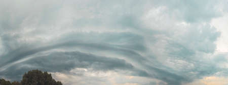 thundercloud rolls across the sky at sunset