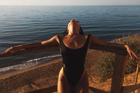 gorgeous girl relaxes on a cliff over the oceanの写真素材