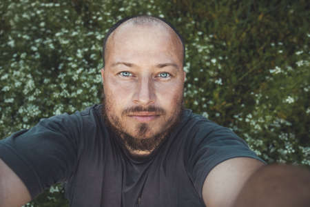 European man with a beard reaching for the camera