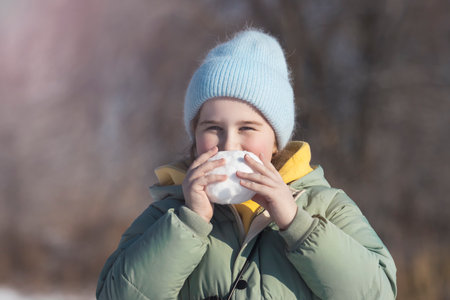 beautiful little girl nibbles a snowballの写真素材