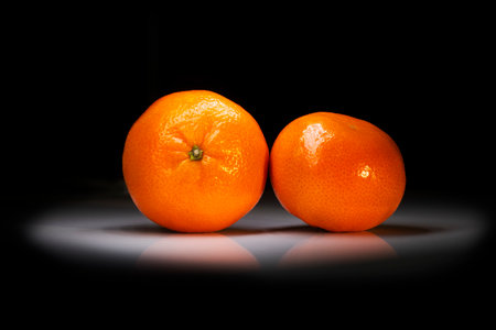 tangerines lie in the dark on the tableの写真素材