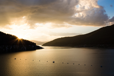 Colorful sunset over the water at Bhumibol Damの写真素材