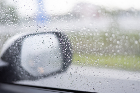 Visibility is not clear in the car mirror due to raining, rain drops on the car glassの写真素材