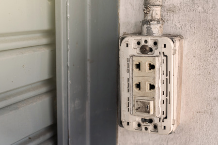 Old power plug on the wall without cover