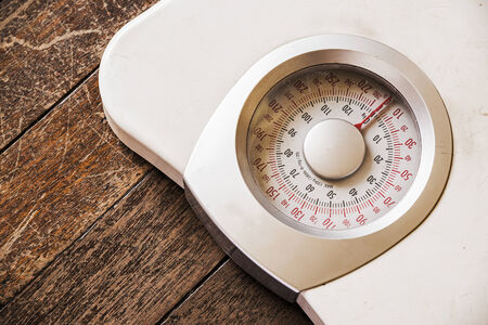 Analog weight scale isolated on wooden floorの写真素材