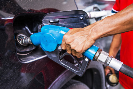 Man refilling the car with fuel at a gas station