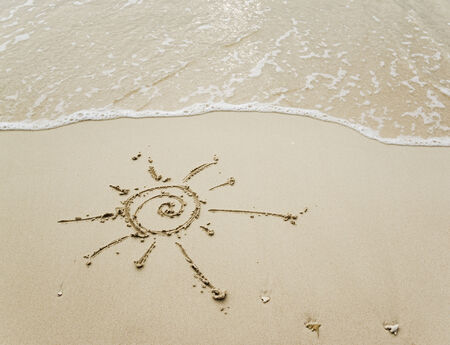 Sun is written on sand backgroundの写真素材