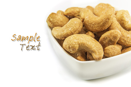 Cashew nuts in white bowl with sample textの写真素材